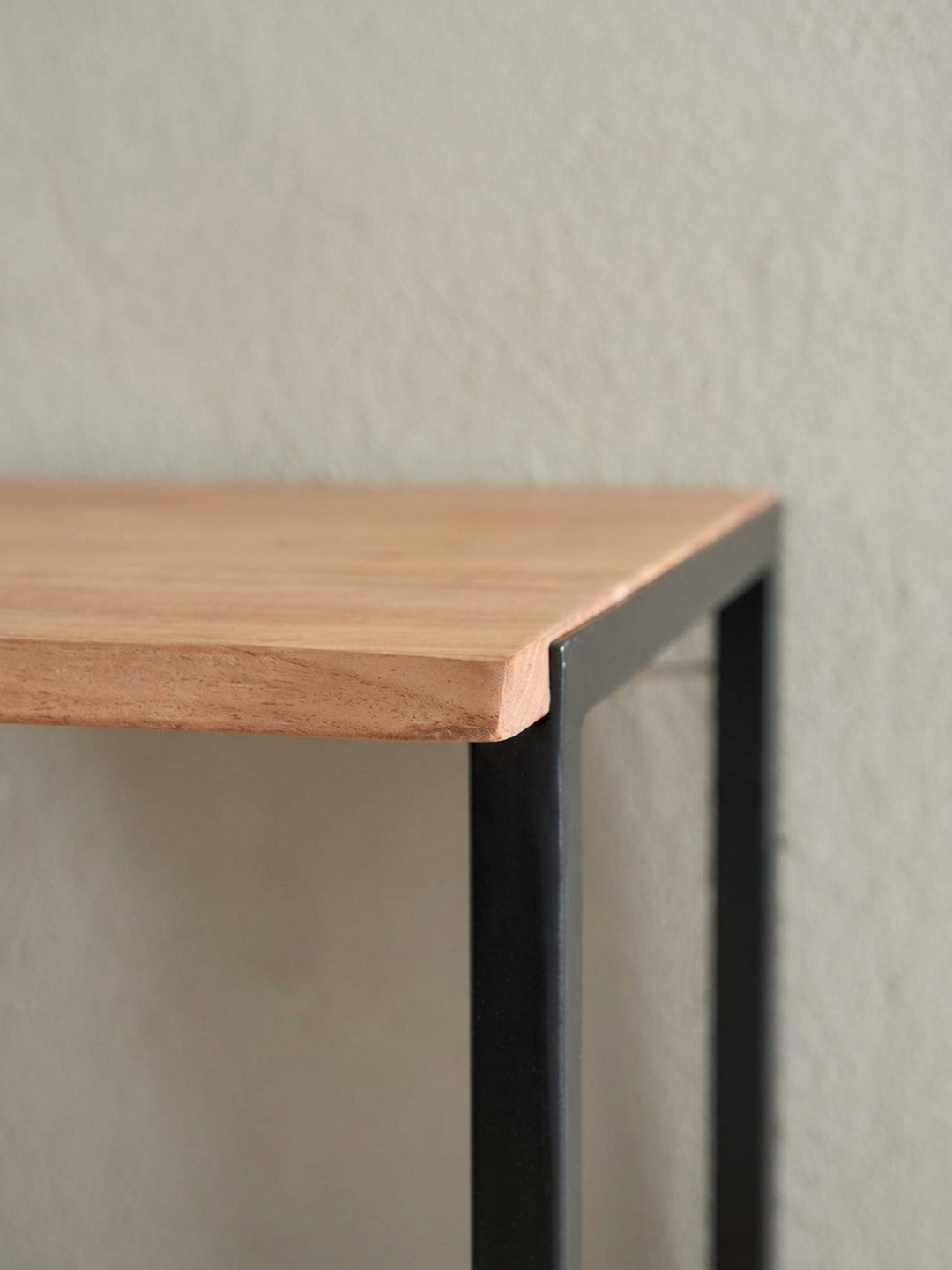 Nahaufnahme der präzise gefertigten, mattschwarzen Haken an der Wandgarderobe für einen modernen und funktionalen Eingangsbereich._