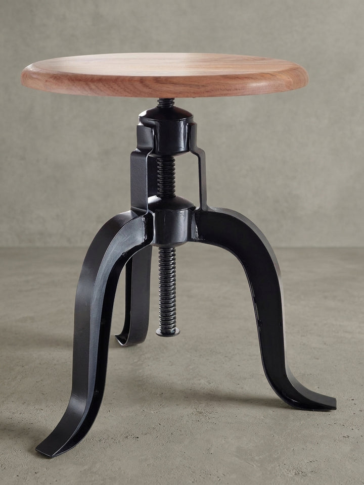 Höhenverstellbarer Drehhocker im Industrial-Look in einer weiteren Perspektive. Die Kombination aus warmem Akazienholz und kühlem, schwarzem Metall wirkt sehr modern._