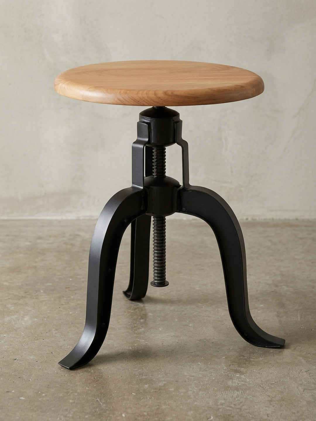 Drehbarer Hocker im Industrie-Stil aus der 3/4-Perspektive. Die massive Akazienholz-Platte und das robuste, höhenverstellbare Metallgestell werden perfekt in Szene gesetzt._