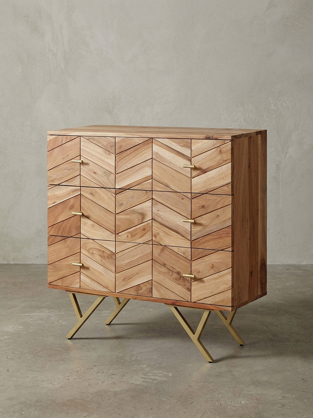 Frontalansicht der Kommode aus massivem Akazienholz, 90 cm breit, auf weißem Hintergrund, die das markante Chevron-Muster und die goldenen Griffe zeigt._