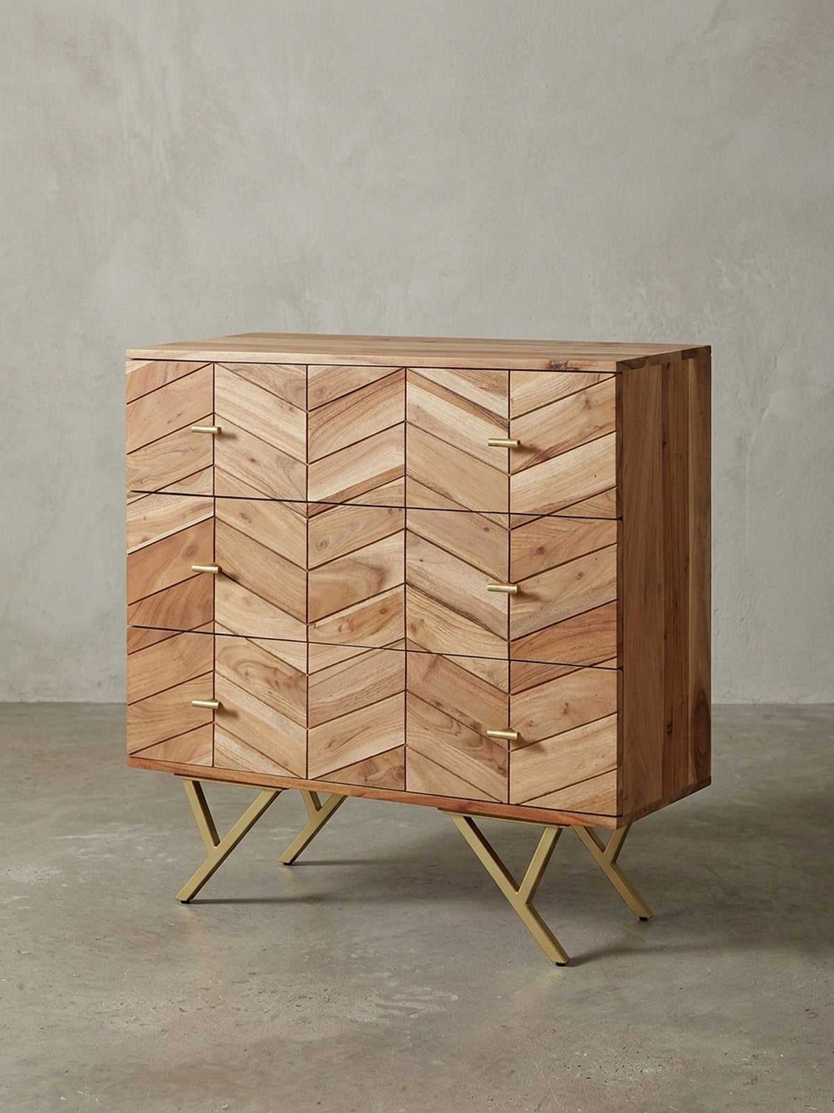 Frontalansicht der Kommode aus massivem Akazienholz, 90 cm breit, auf weißem Hintergrund, die das markante Chevron-Muster und die goldenen Griffe zeigt.