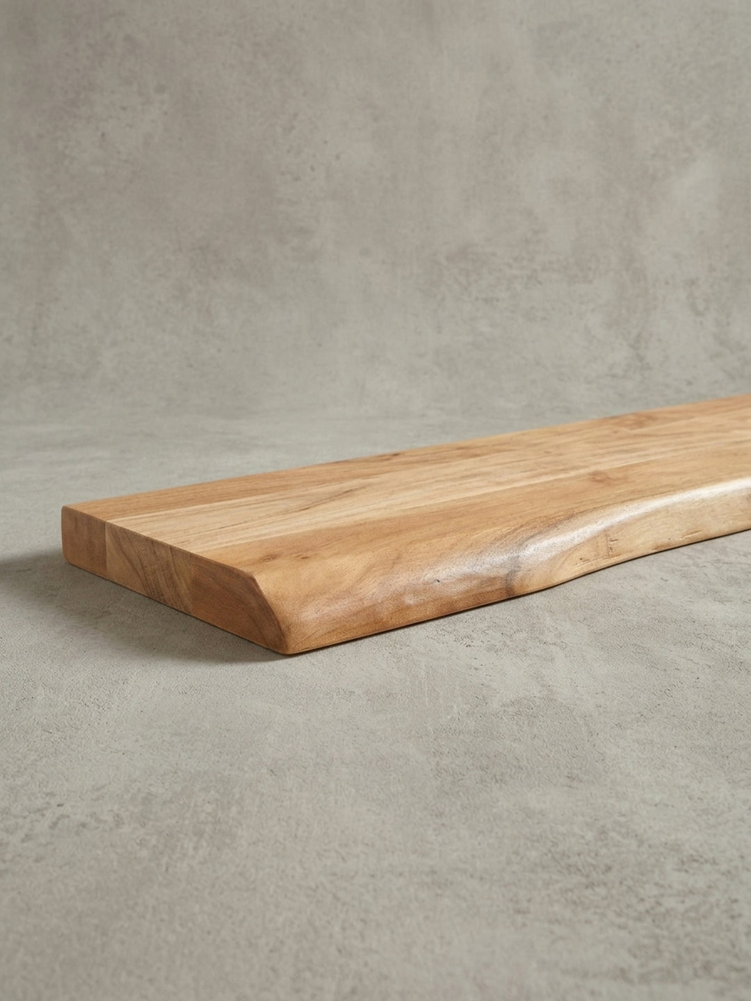 Makroaufnahme der abgerundeten Ecke und der glatt geschliffenen Live-Edge-Kante des massiven Wandboards, ein Detail handwerklicher Qualität._