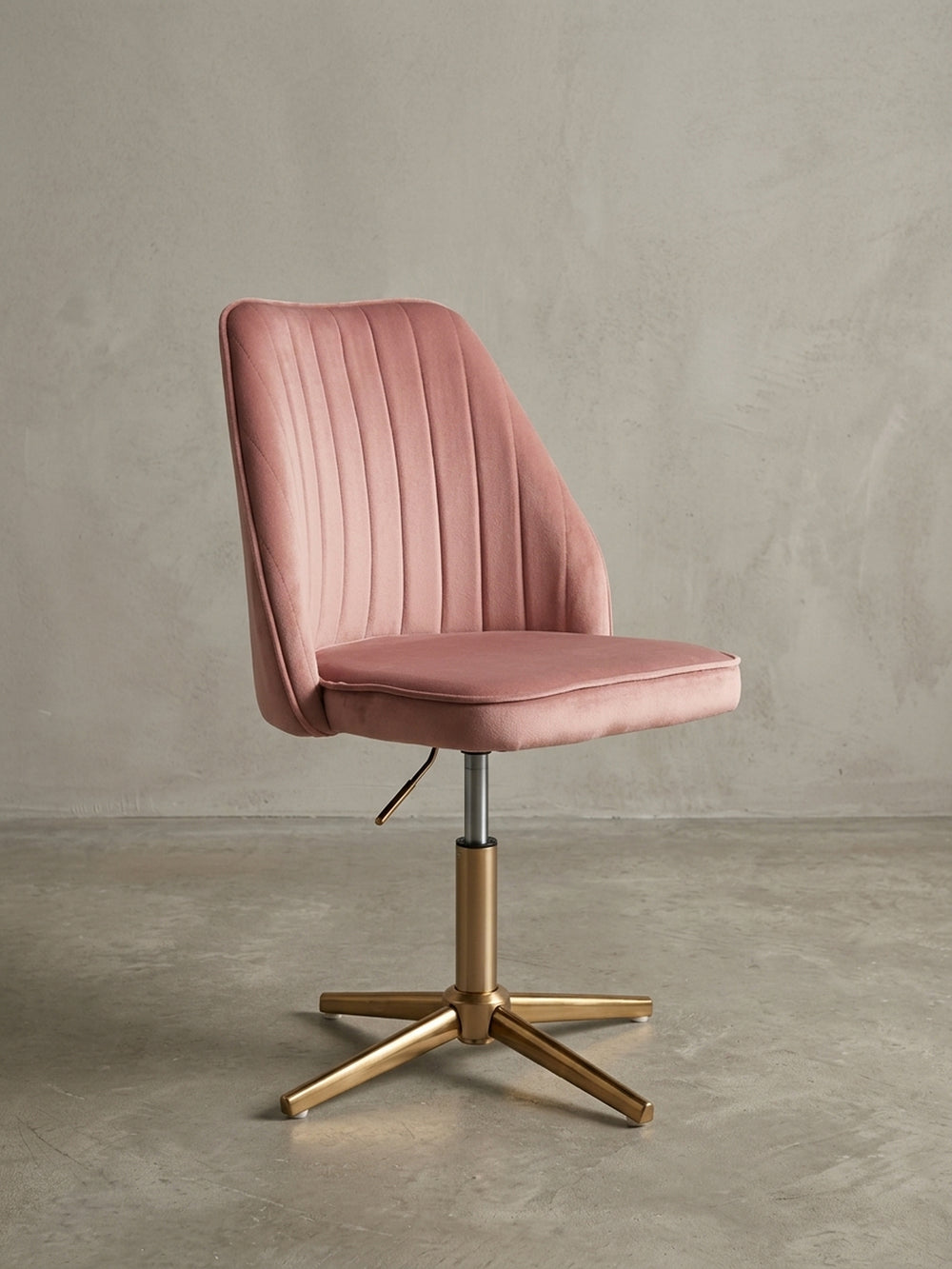 Perspektivische Ansicht des rosa Samt-Drehstuhls, die das Zusammenspiel von weichem Polster und dem glänzenden, goldenen Fünf-Sterne-Fußkreuz betont._