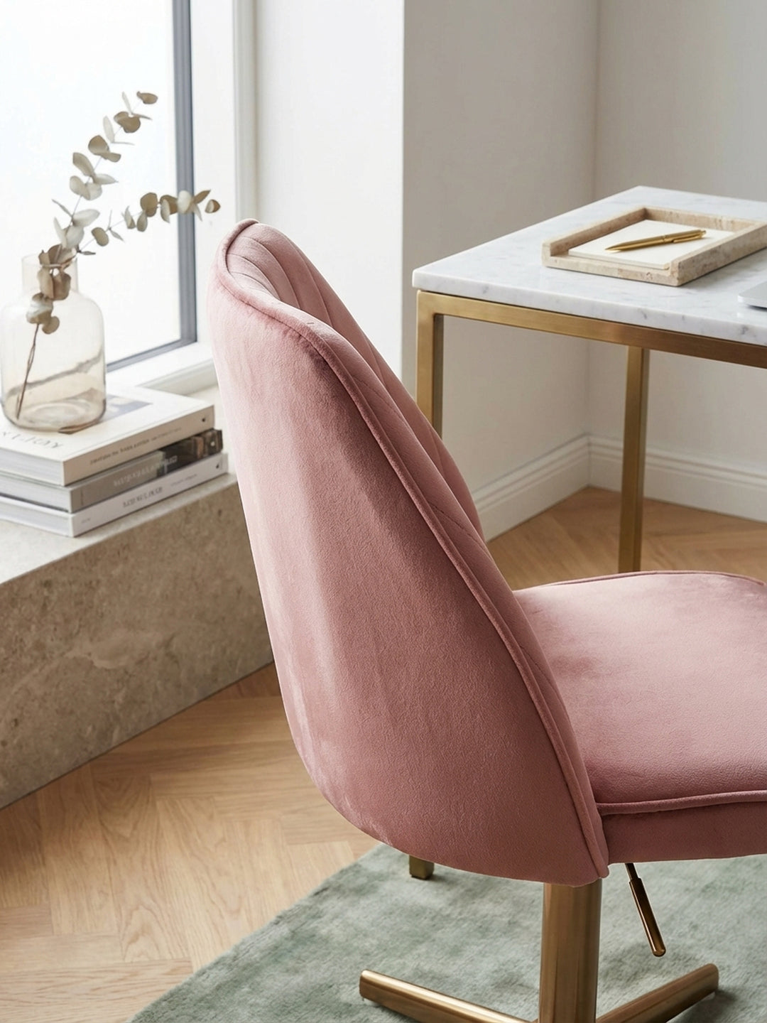 Makroaufnahme der feinen Textur des rosa Samtbezugs und der präzisen Kanalsteppung des Design-Schreibtischstuhls, die die hohe Qualität des Materials zeigt._