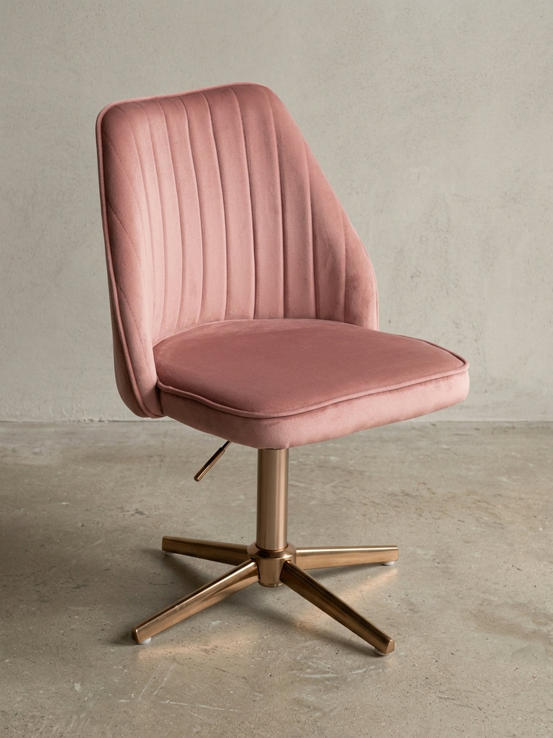 Moderner Schreibtischstuhl in Rosa Samt mit goldenem Fußkreuz, Frontalansicht auf weißem Hintergrund, zeigt die symmetrische Schalenform und das elegante Design._