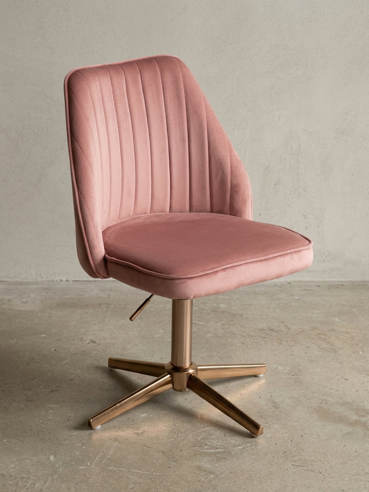 Moderner Schreibtischstuhl in Rosa Samt mit goldenem Fußkreuz, Frontalansicht auf weißem Hintergrund, zeigt die symmetrische Schalenform und das elegante Design._