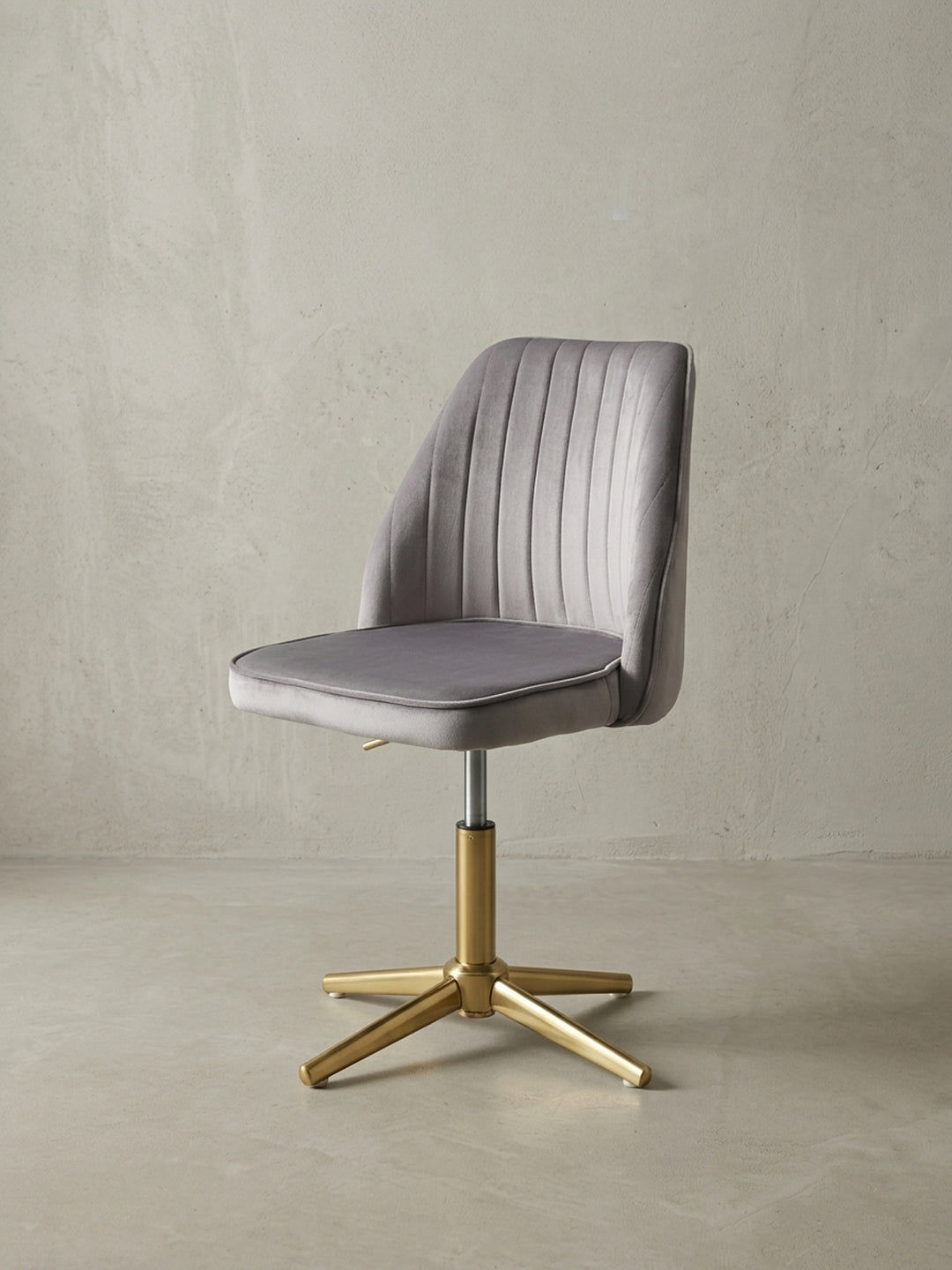 Seitenansicht des höhenverstellbaren Drehstuhls in Grau und Gold, das schlanke Profil und die Proportionen des Design-Stuhls sind klar erkennbar._
