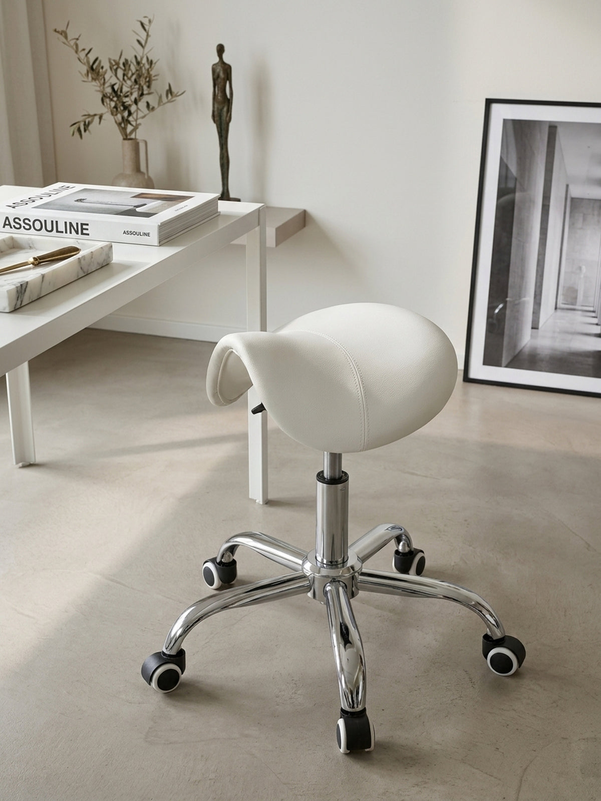 Nahaufnahme der weißen Kunstlederoberfläche des Praxishockers, bei der die feinen, präzisen Steppnähte der ergonomischen Sattelform im hellen Tageslicht gut sichtbar sind._