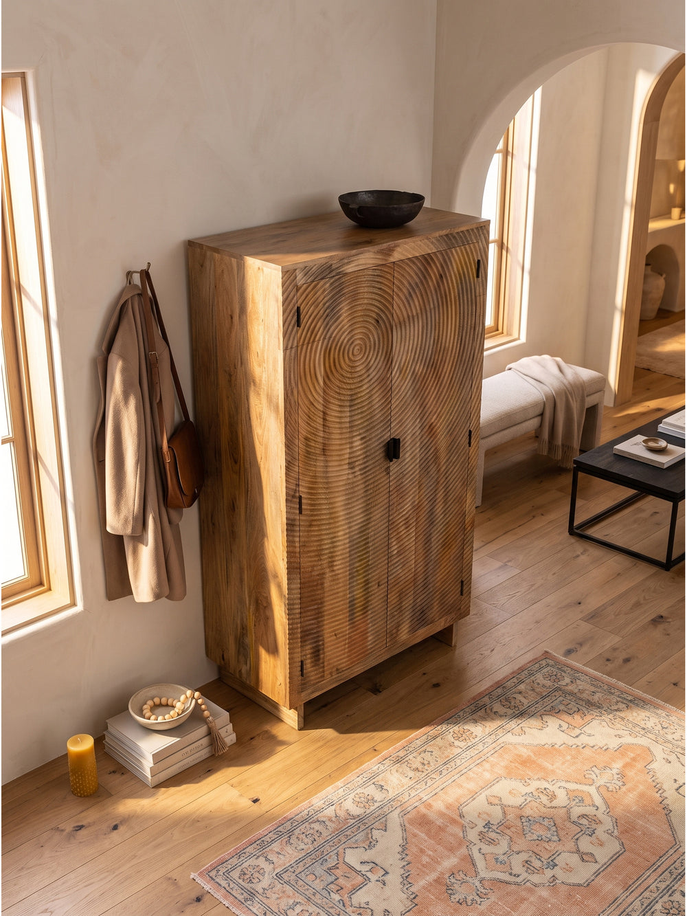 Blick von oben auf den handgefertigten Holzschrank im Wohnbereich neben einem beigen Bouclé Sessel auf Eichenparkett_