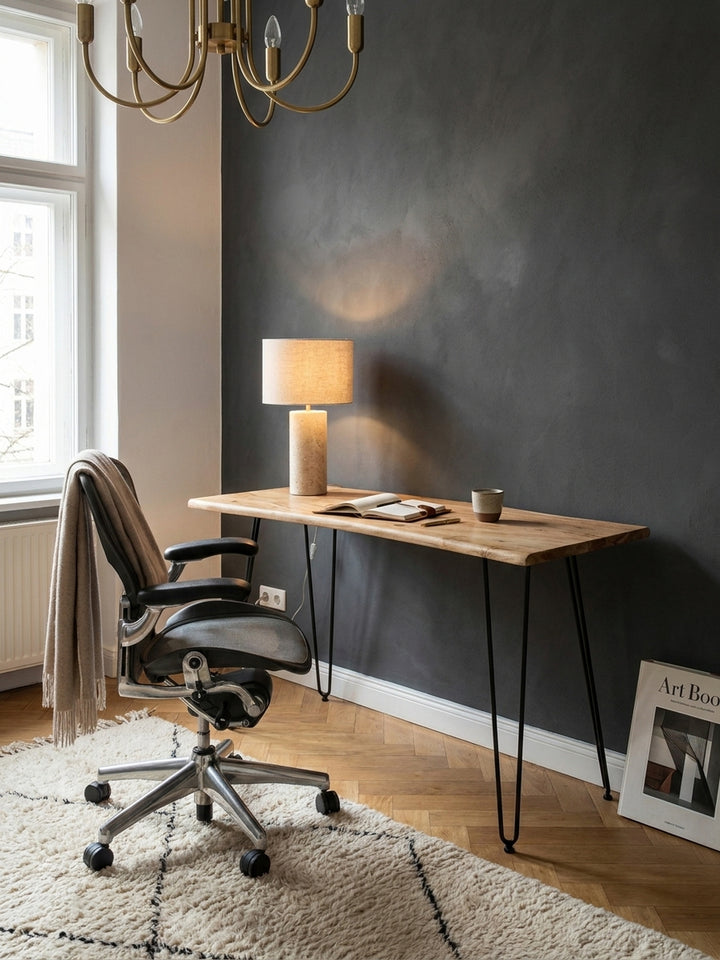 Der Massivholz-Schreibtisch mit schwarzen Haarnadelbeinen harmoniert mit einem Ledersessel und schafft eine edle Homeoffice-Atmosphäre._