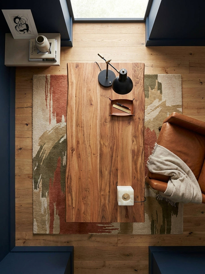 Von oben betrachtet, zeigt der 160x80 cm große Massivholz-Schreibtisch seine organische Baumkante und die großzügige Arbeitsfläche in einem modernen Arbeitszimmer._
