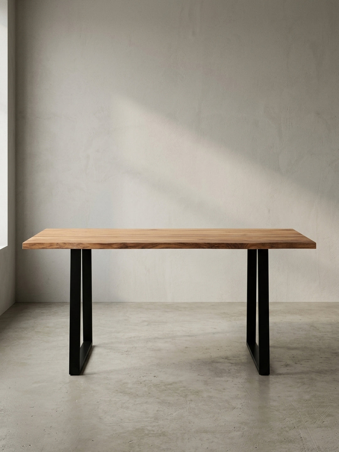 Frontansicht des Schreibtisches 120x60 cm aus Akazie Massivholz mit charakteristischen schwarzen Trapezbeinen aus Metall, freigestellt._