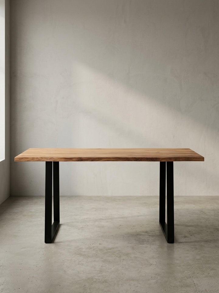 Frontansicht des Schreibtisches 120x60 cm aus Akazie Massivholz mit charakteristischen schwarzen Trapezbeinen aus Metall, freigestellt._