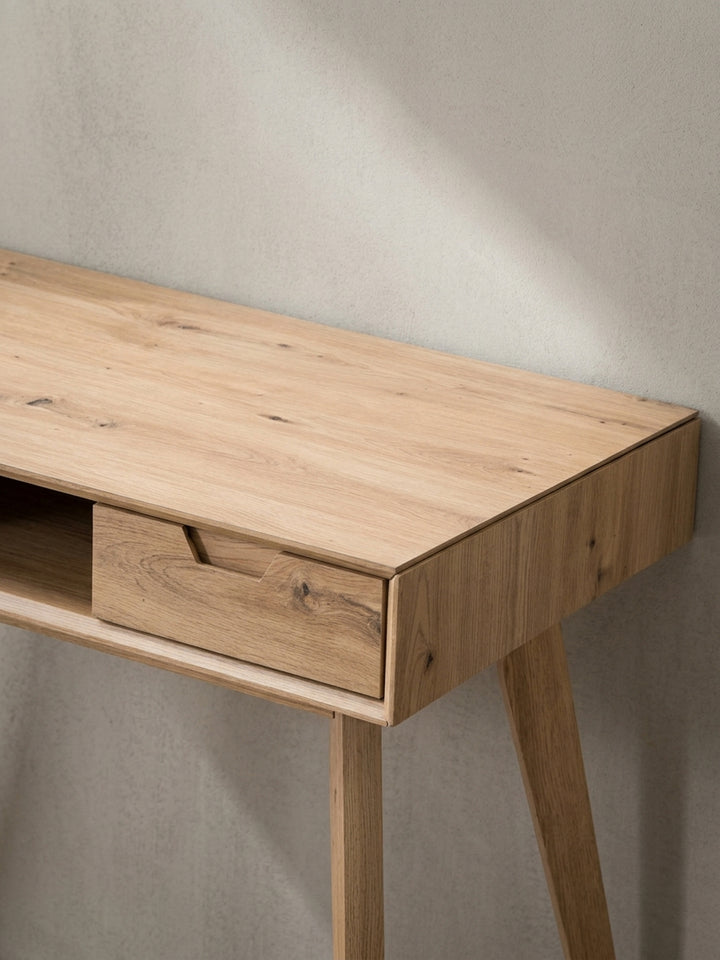 Der Design-Schreibtisch aus einer alternativen Perspektive, die die grifflosen Schubladen und die klare Linienführung betont._