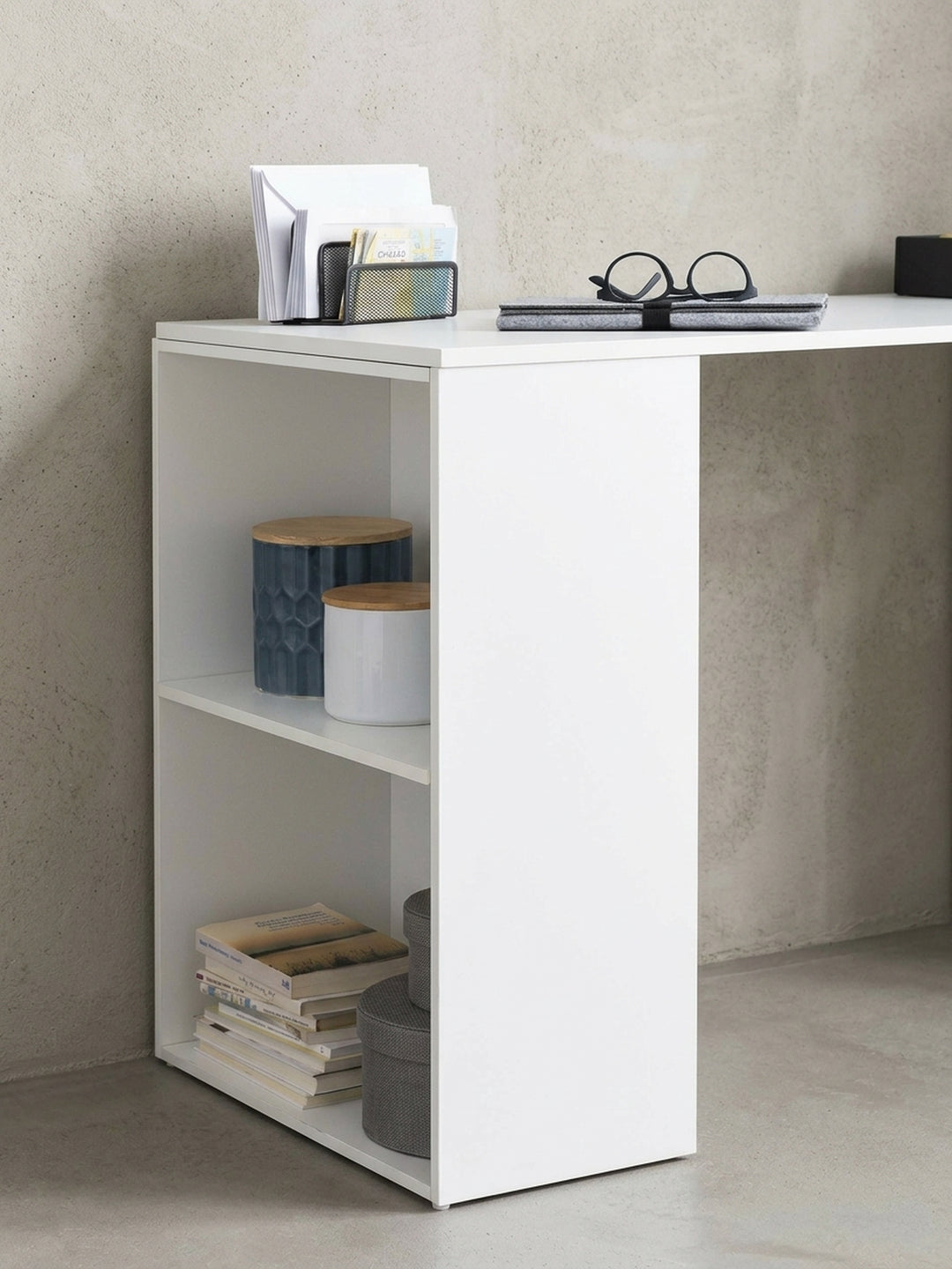 Alternative Perspektive des modernen Arbeitstisches. Fokus auf die stufenlose Verbindung zwischen der 74,5 cm hohen Tischplatte und dem seitlichen Regalteil in Weiß._