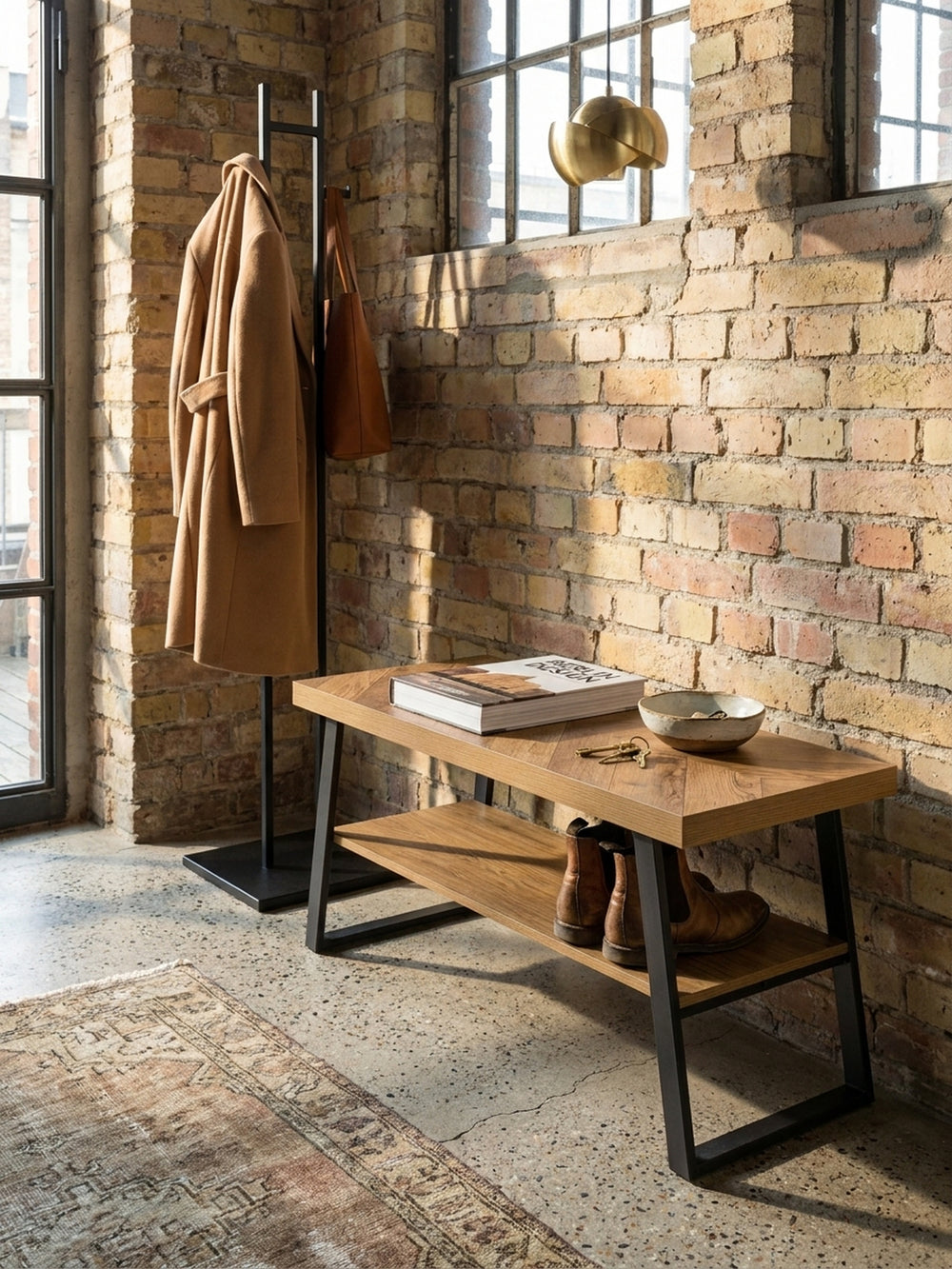 Die schmale Flurbank mit schwarzem Metallgestell harmoniert perfekt mit einem Vintage-Teppich vor einer dezenten Wandfarbe._