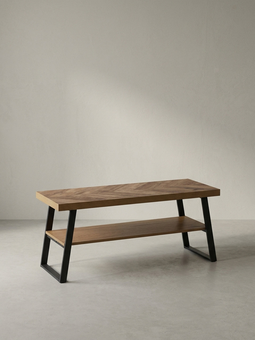 Schräge 3/4-Perspektive der Garderobenbank, die die Tiefe der Sitzfläche von 40 cm und das schlanke, schwarze Metallgestell zeigt._