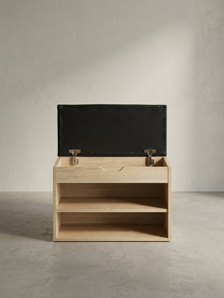 Detailaufnahme der funktionalen Griffaussparung an der Frontklappe der kleinen Schuhablage, die das schnelle Öffnen des Polsterdeckels ermöglicht._
