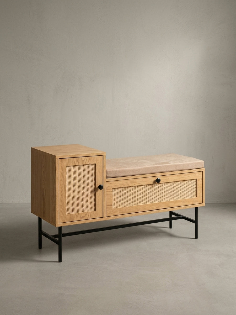 Schräge 3/4-Ansicht der Sitzbank mit Rattan, die die Tiefe des Möbelstücks und die schlanken, schwarzen Metallbeine hervorhebt._