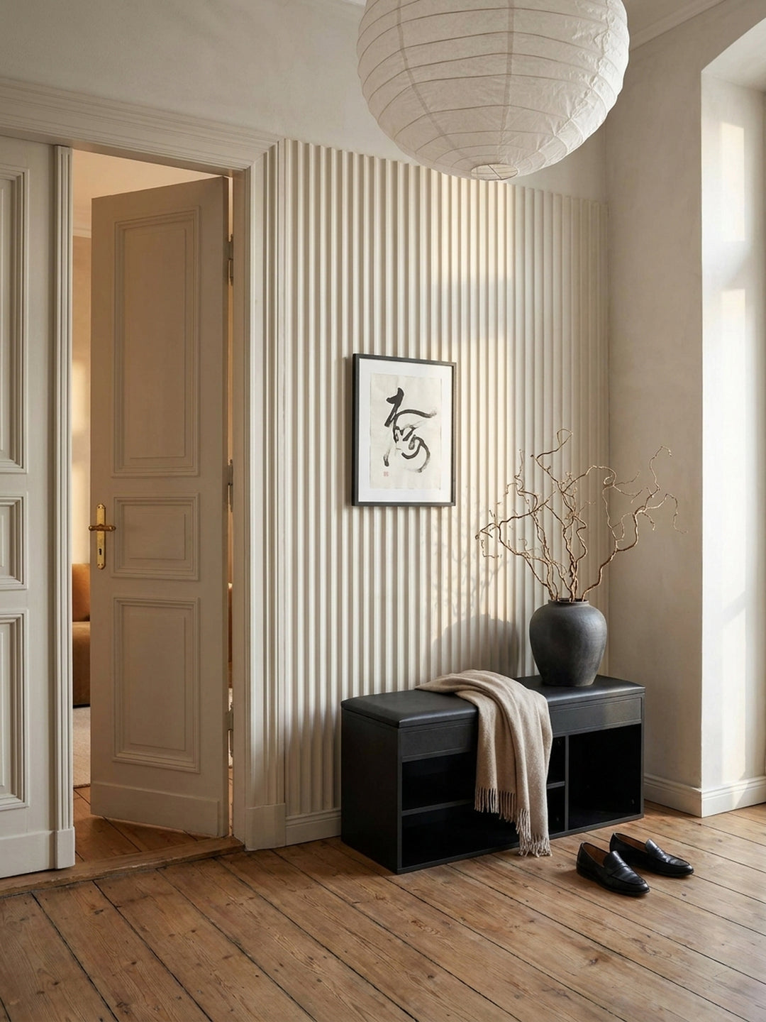 Schwarze Garderoben-Bank mit Stauraum als Teil einer kompletten Flureinrichtung, kombiniert mit einer Wandgarderobe und einem beigen Kissen._