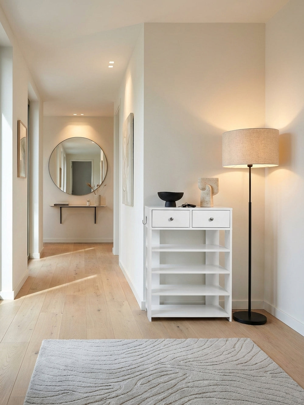 Modernes weißes Schuhregal mit Schubladen im Flur einer stilvollen Wohnung, kombiniert mit einem Holzboden und einer eleganten Vase mit Tulpen für einen einladenden Eingang._