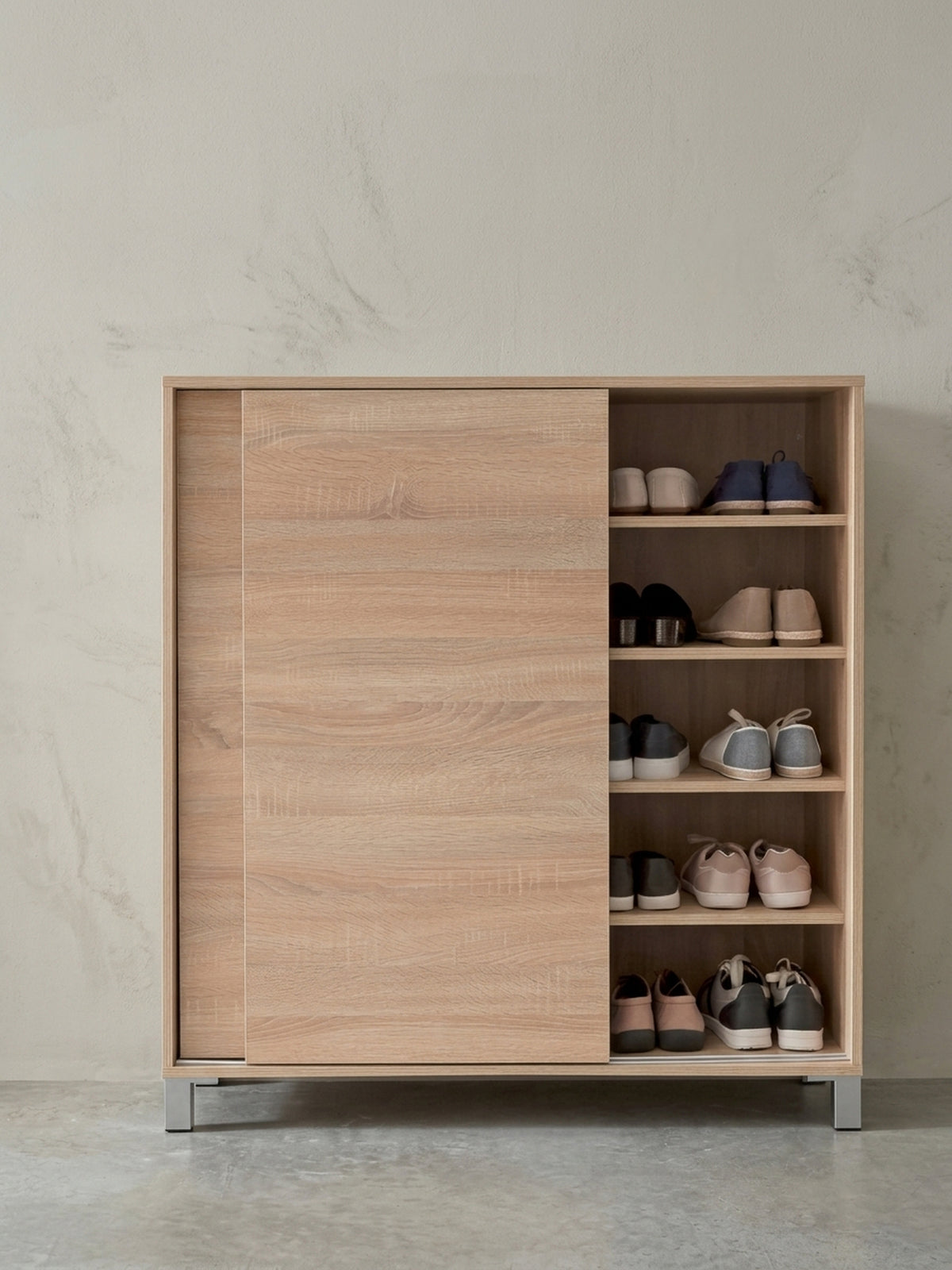 Detail der eckigen silbernen Möbelfüße des Schuhschranks. Der subtile Kontrast zum warmen Holzton unterstreicht das moderne Design dieses geräumigen Dielenmöbels für 20 Paar Schuhe._