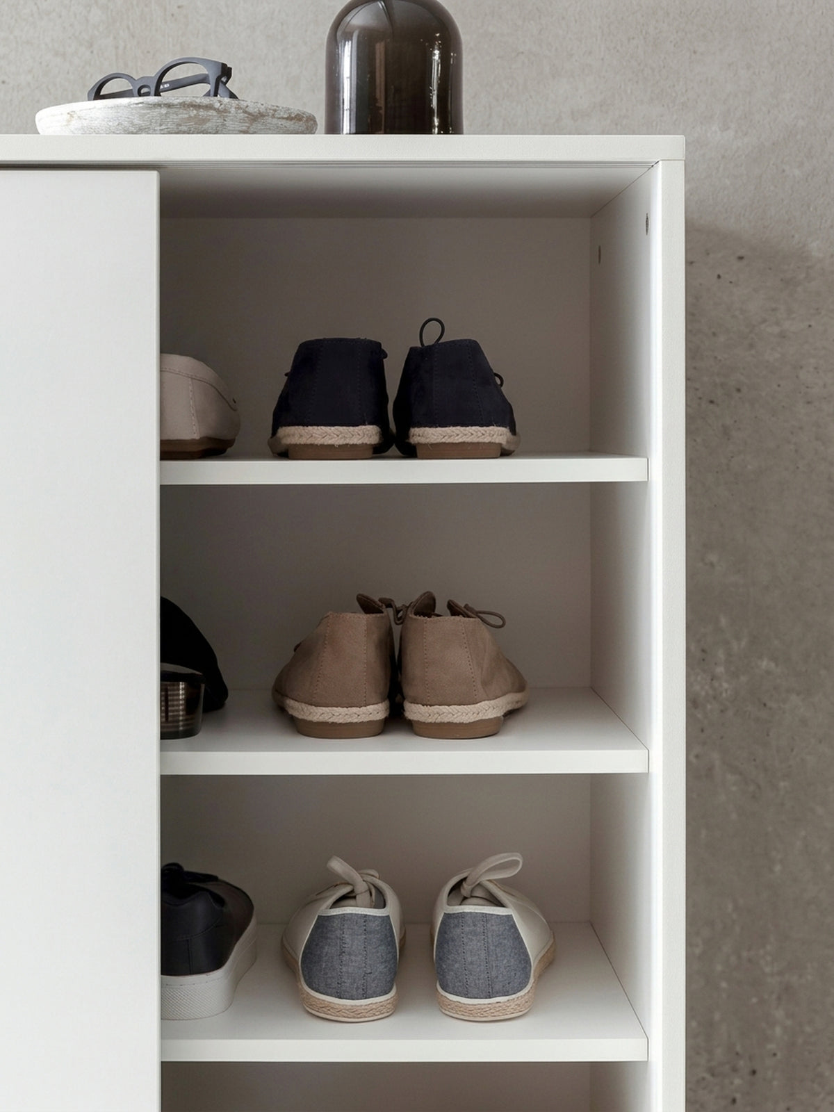 Moderner Schuhschrank in Weiß mit Schiebetüren und eleganten Metallfüßen. Die 100 cm breite Schuhkommode bietet viel Stauraum für Schuhe im Eingangsbereich.