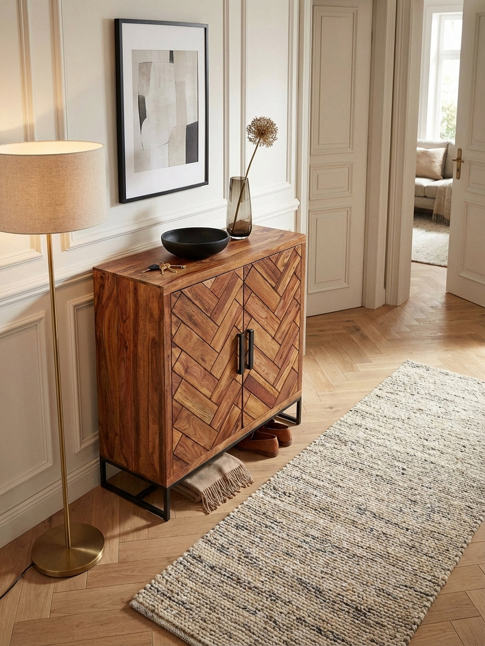 Flurkommode mit Fischgrät-Design von oben, zeigt die 100x40 cm große Ablagefläche und die harmonische Integration in den Raum mit einem Wollteppich._