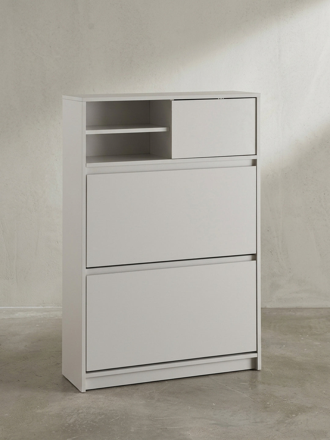 Schräger Blick auf den weißen Schuhkipper, der die schlanke Tiefe von 24 cm und die grifflose, minimalistische Frontgestaltung zeigt._