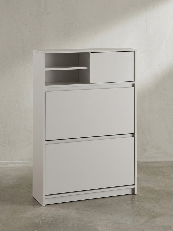 Schräger Blick auf den weißen Schuhkipper, der die schlanke Tiefe von 24 cm und die grifflose, minimalistische Frontgestaltung zeigt._