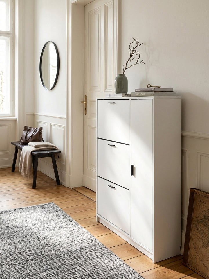 Schuhkommode mit 90 cm Breite als Teil einer Garderobeneinrichtung neben einem großen runden Spiegel und einer minimalistischen Wandgarderobe._