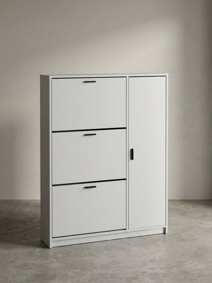 Frontansicht des hohen, schmalen Schuhschranks in Weiß, mit drei Schuhkippern und einer Seitentür, freigestellt vor neutralem Hintergrund._