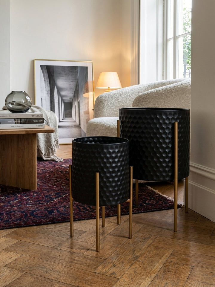 Detailaufnahme der mattschwarzen Oberfläche eines Design-Blumentopfs, die die fühlbare 3D-Wabenstruktur und die hochwertige Pulverbeschichtung des Metalls hervorhebt._