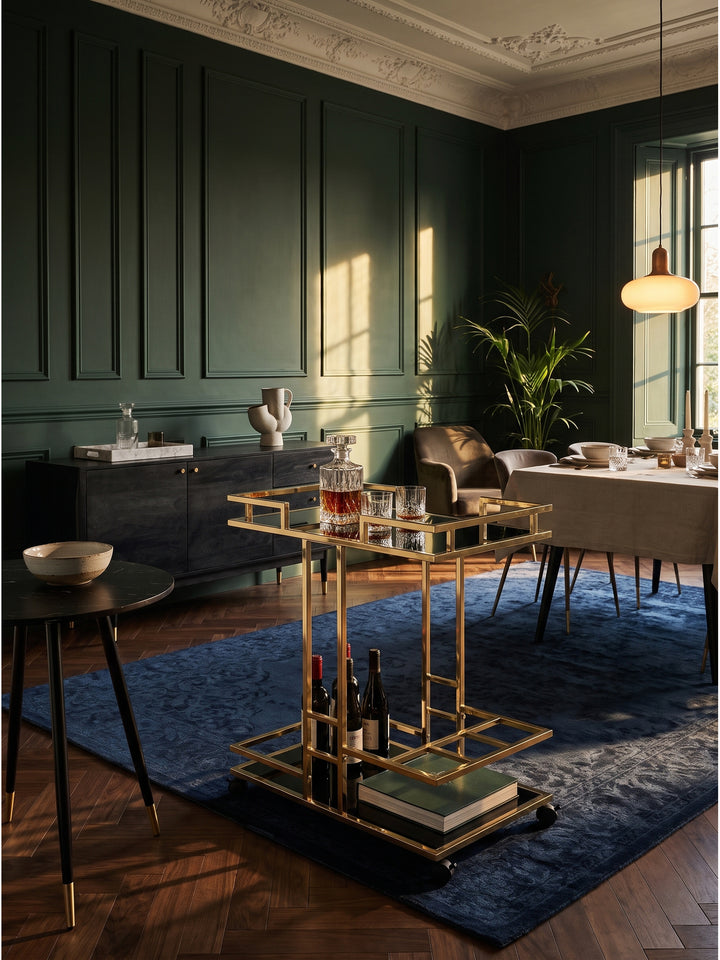 Eleganter Servierwagen aus Metall und Glas 67x83x43 cm in Gold und Schwarz vor smaragdgrüner Wand im Art Deco Salon_