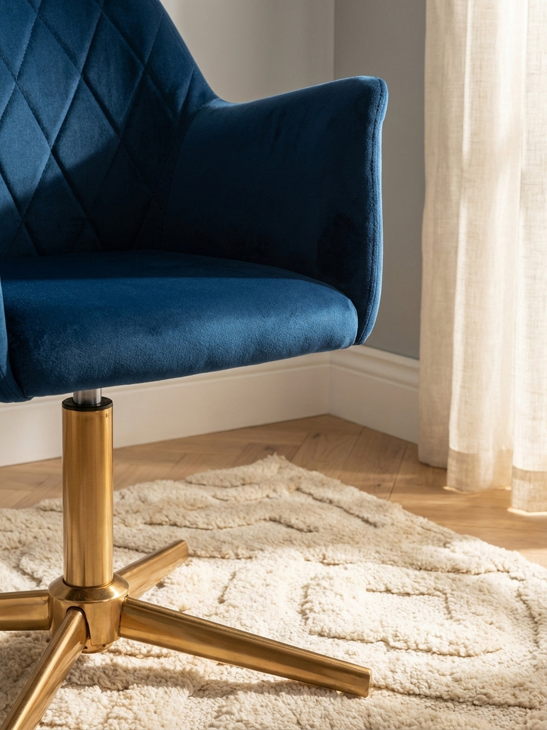 Detailaufnahme des luxuriösen dunkelblauen Samtbezugs. Die hochwertige Rautensteppung und die weiche Textur des Arbeitsstuhls sind deutlich zu erkennen._