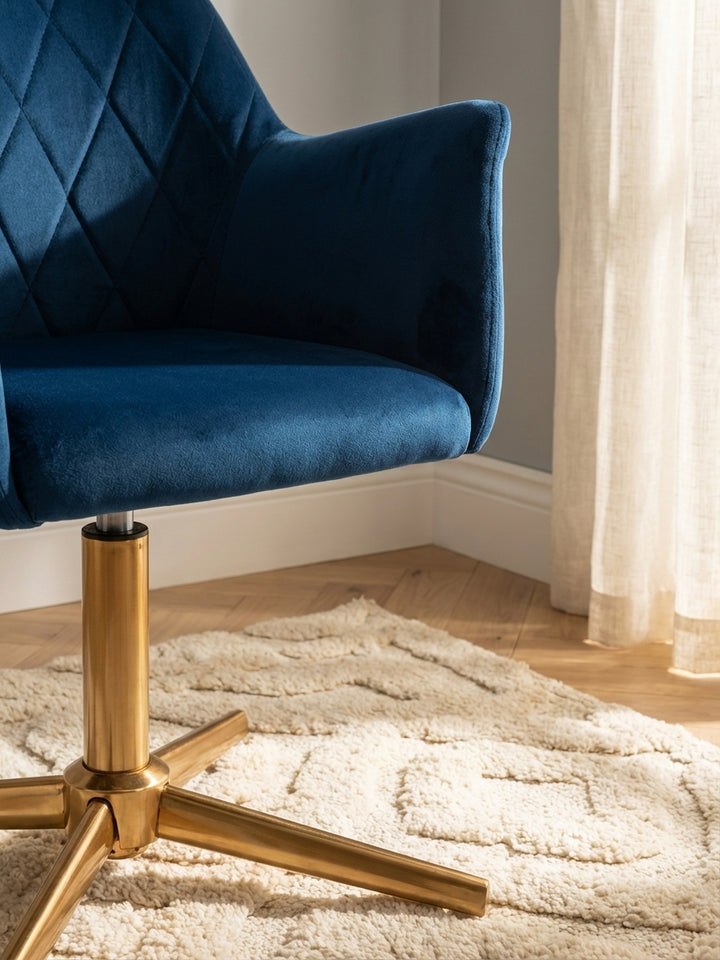 Detailaufnahme des luxuriösen dunkelblauen Samtbezugs. Die hochwertige Rautensteppung und die weiche Textur des Arbeitsstuhls sind deutlich zu erkennen._