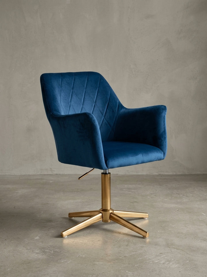 Frontansicht des Design-Schreibtischstuhls in Dunkelblau Samt. Der Drehstuhl mit Armlehnen und goldenem Drehkreuz ist freigestellt auf weißem Hintergrund zu sehen._