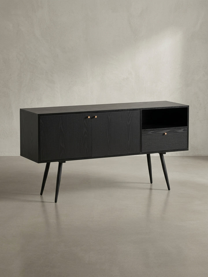 Gesamtübersicht des zeitlosen Sideboards mit schwarzem Eiche-Dekor, das durch seine asymmetrische Aufteilung und mid-century inspirierte Beine besticht._