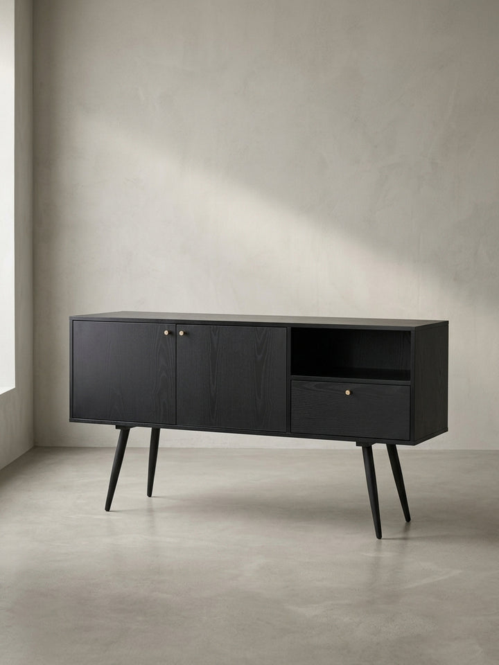 Frontalansicht des schwarzen Sideboards 140x75cm mit Eiche-Dekor und Goldgriffen, das auf schlanken, ausgestellten Beinen steht und ein klares, modernes Design zeigt._