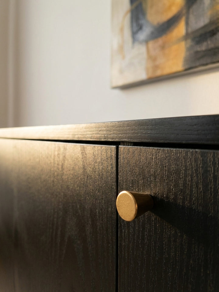 Detailaufnahme der schwarzen Oberfläche des Sideboards, die eine feine, reliefartige Eichenholzmaserung und die matte, elegante Haptik des Dekors offenbart._