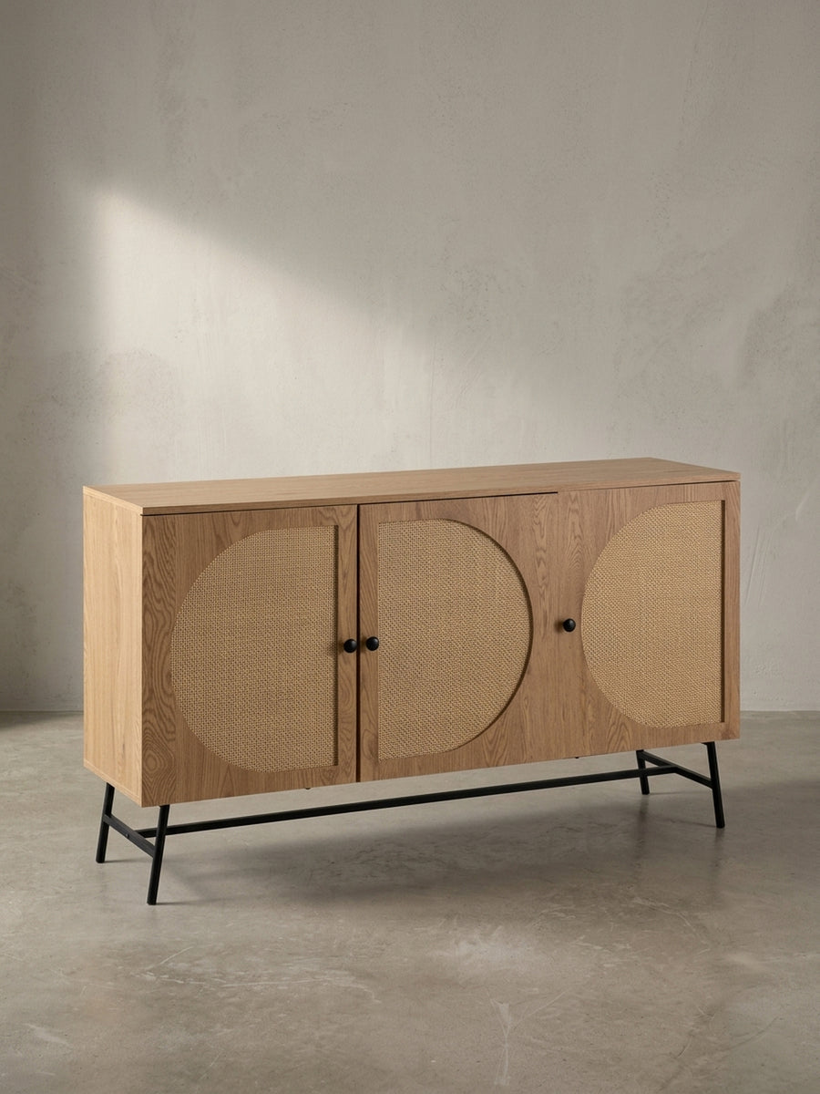 Frontansicht des Sideboards mit 140 cm Breite, das sein grafisches Design mit runden Rattan-Einsätzen auf einem klaren, weißen Hintergrund präsentiert._