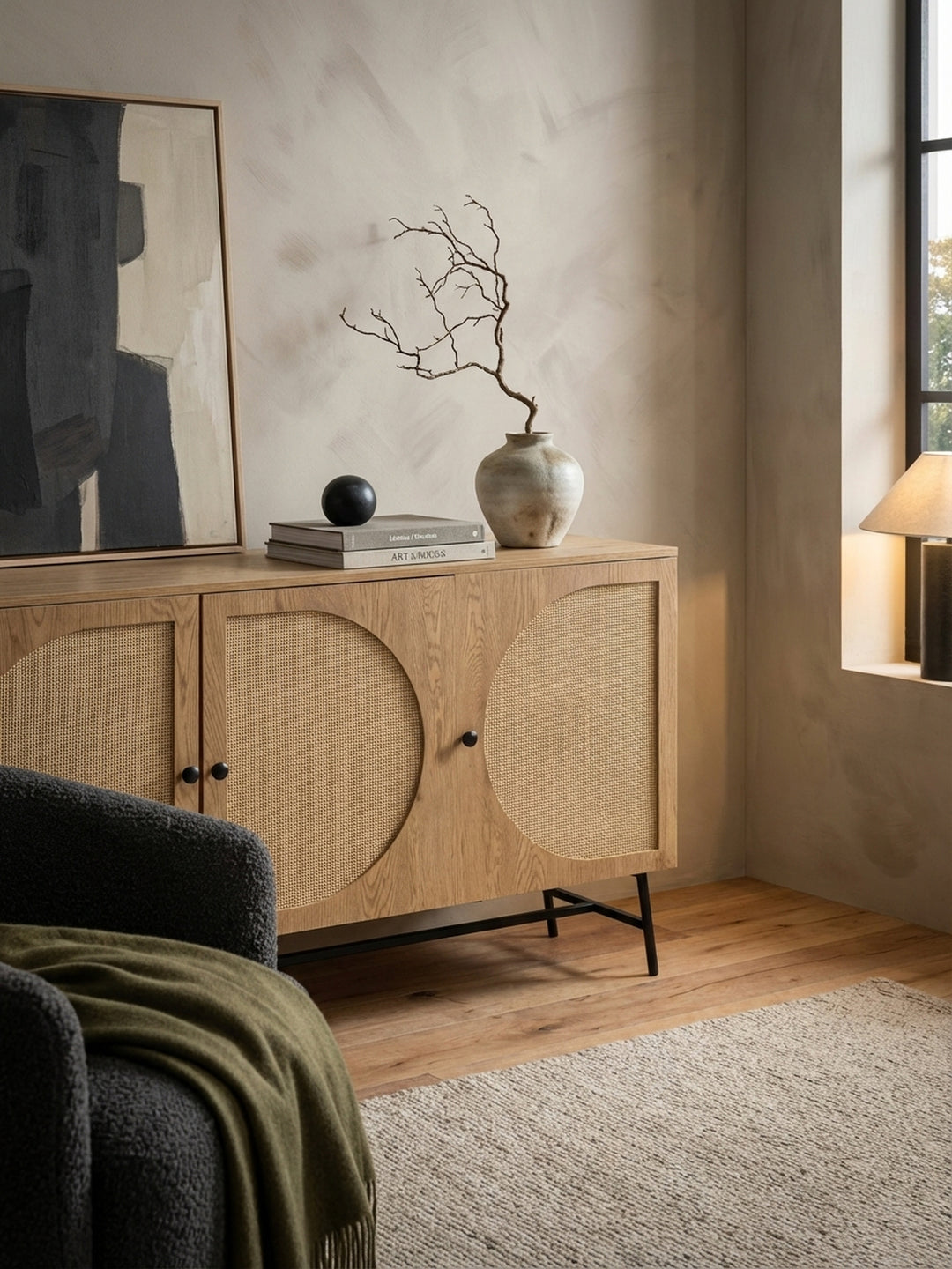 Detailansicht der Anrichte in Eiche-Optik, auf der eine Keramikvase mit Trockenblumen und ein Stapel Architekturbücher für ein stilvolles Ambiente sorgen._
