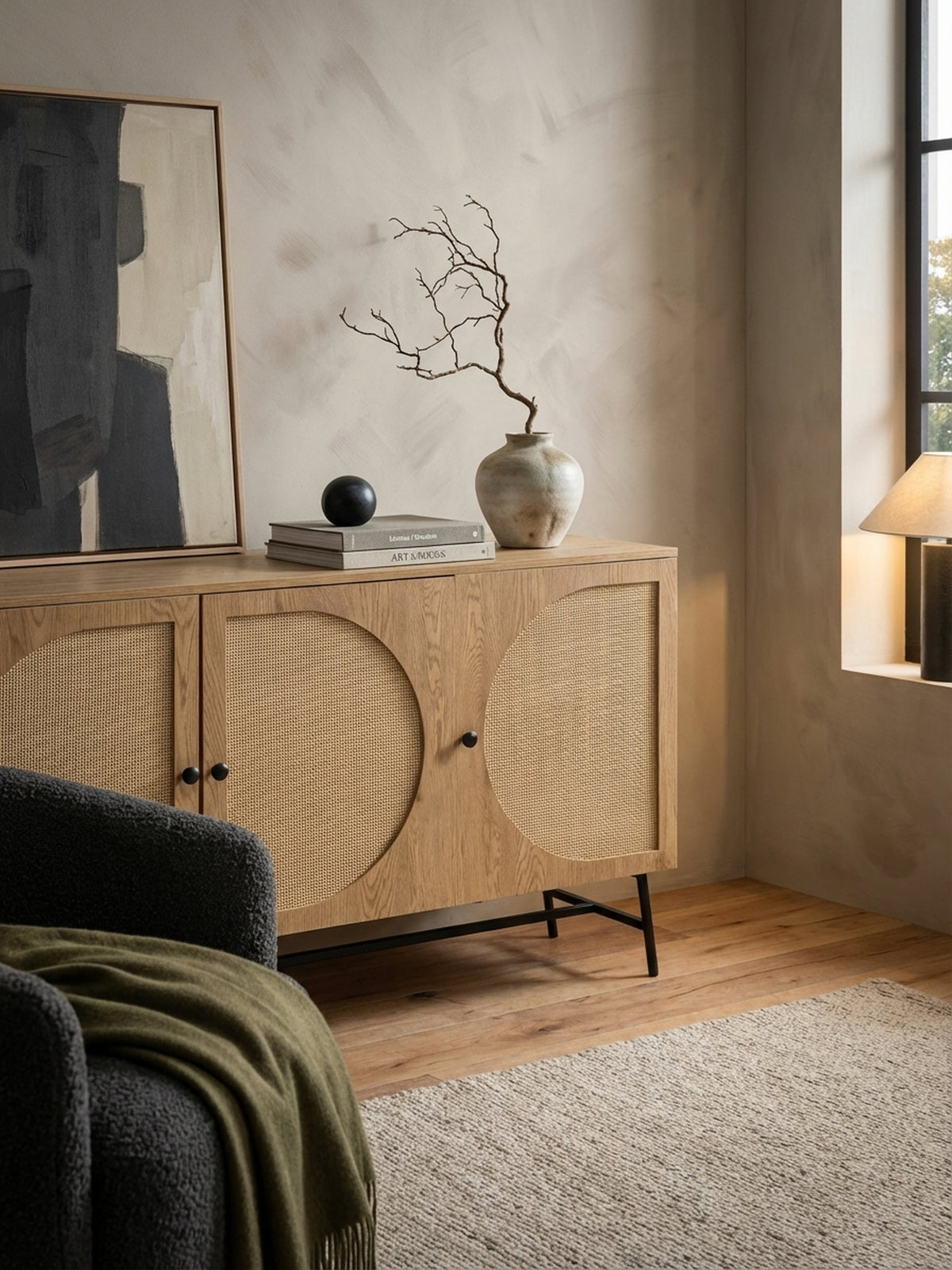 Detailansicht der Anrichte in Eiche-Optik, auf der eine Keramikvase mit Trockenblumen und ein Stapel Architekturbücher für ein stilvolles Ambiente sorgen.