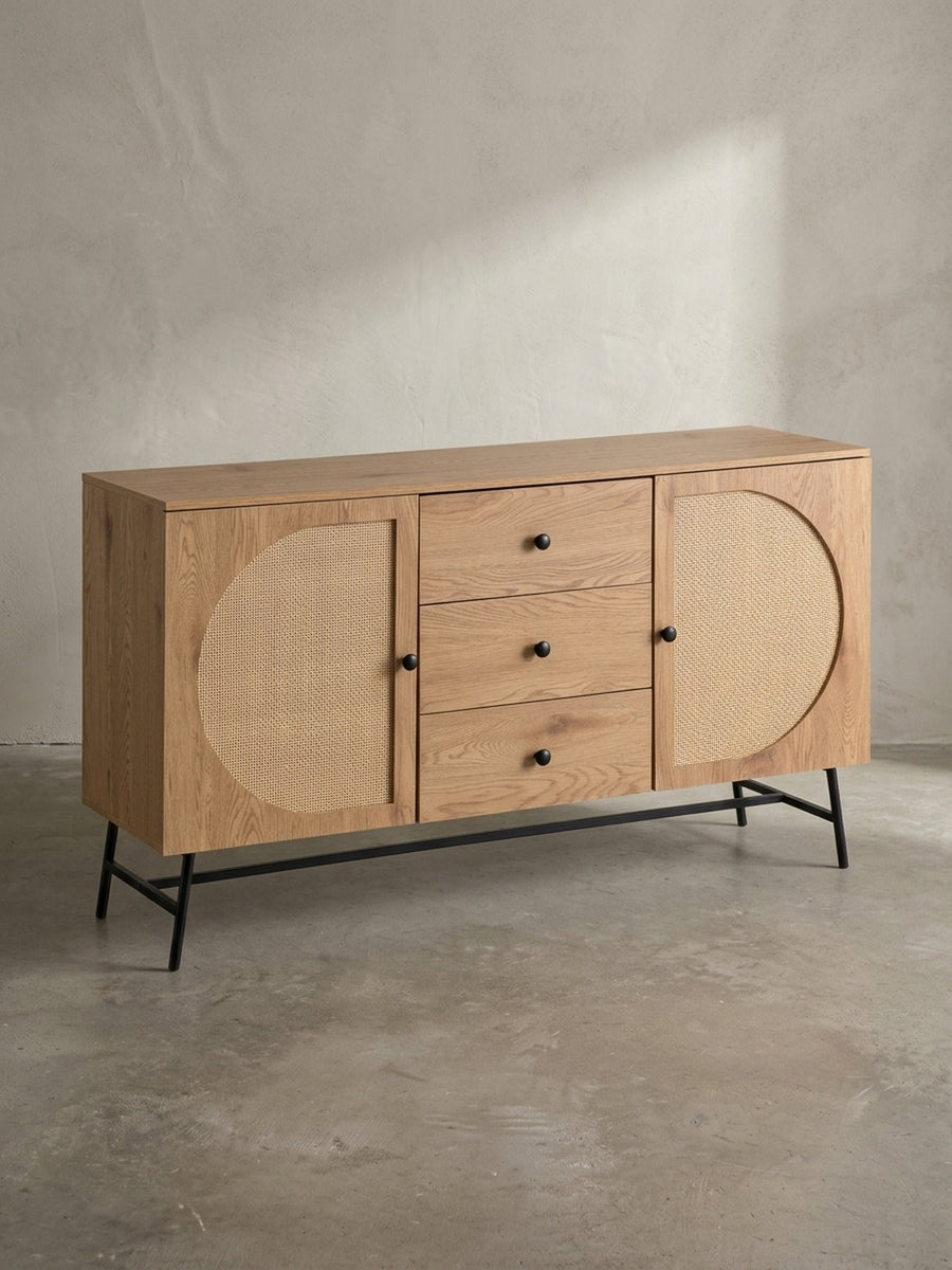 Frontansicht des Sideboards mit Eiche-Dekor, drei Schubladen und zwei Türen mit Rattan-Geflecht, freigestellt vor weißem Hintergrund._