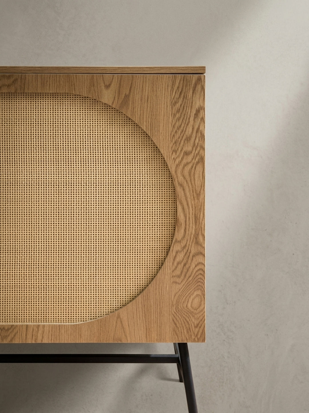Alternative Perspektive auf die Kommode, die den Kontrast zwischen der glatten Holzoberfläche der Schubladen und dem texturierten Rattan-Geflecht betont._