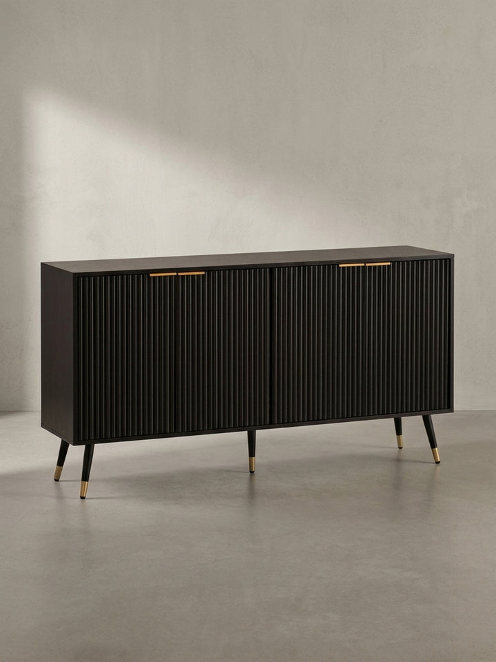 Frontansicht des 150 cm breiten Sideboards in Schwarz mit geriffelten Türen, goldfarbenen Griffen und konischen Metallbeinen auf weißem Hintergrund._