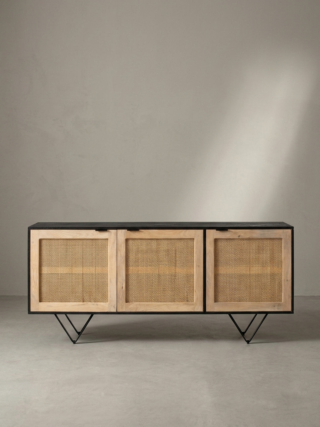 Seitenansicht des geräumigen Rattan-Sideboards zur Veranschaulichung der 45 cm Tiefe und der markanten pulverbeschichteten Eisenfüße._