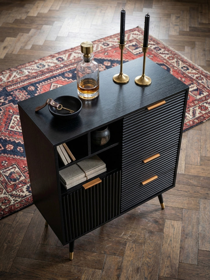Von oben betrachtet, zeigt sich das schwarze Sideboard mit Eiche-Dekor auf einem Fischgrätparkett, arrangiert mit einem Ledersessel und einem Beistelltisch aus Marmor._