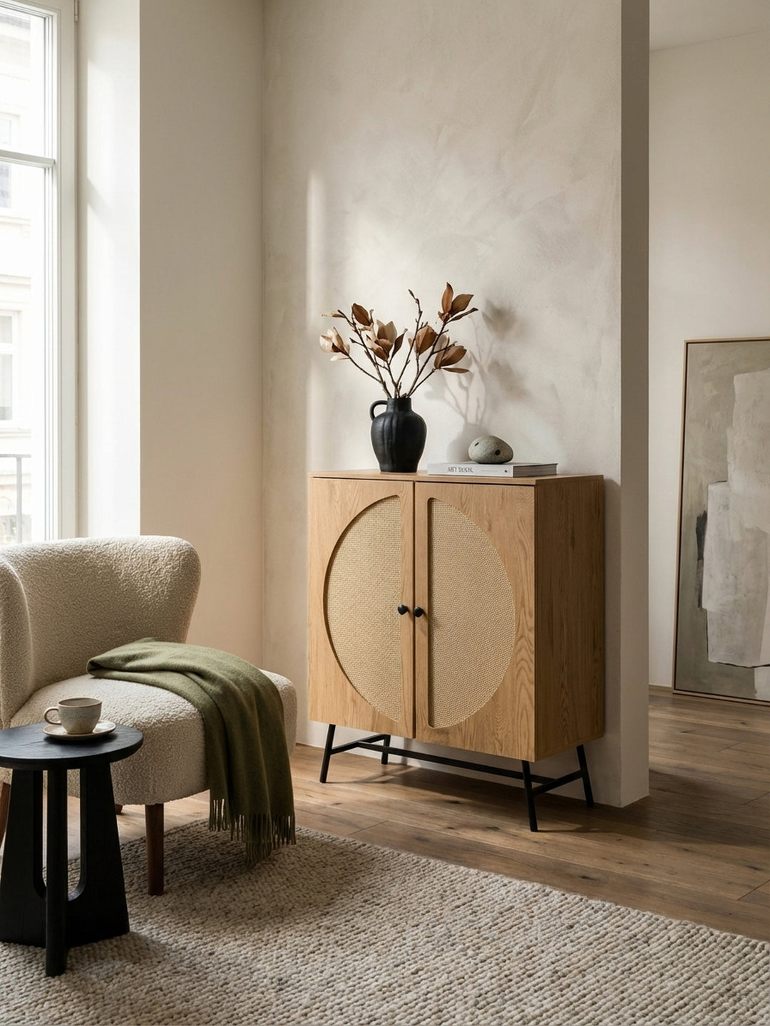 Der 103cm hohe Kommodenschrank mit Rattan-Türen harmoniert als praktischer Stauraum mit einem Sessel aus Bouclé-Stoff._
