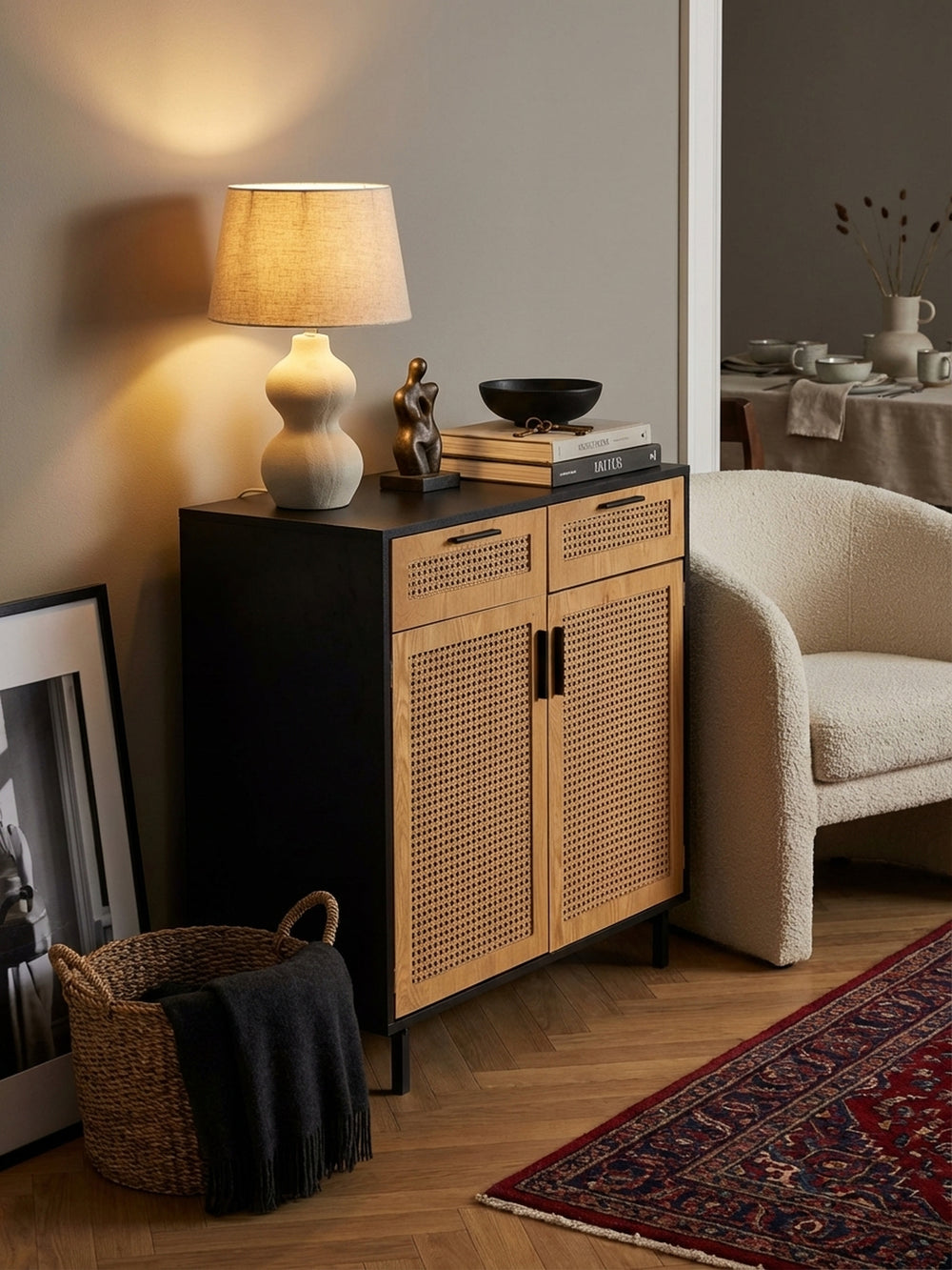 Ein offenes Buch und eine Kaffeetasse auf der schwarzen Ablage der Kommode, die eine wohnliche und persönliche Atmosphäre im Wohnbereich schafft._